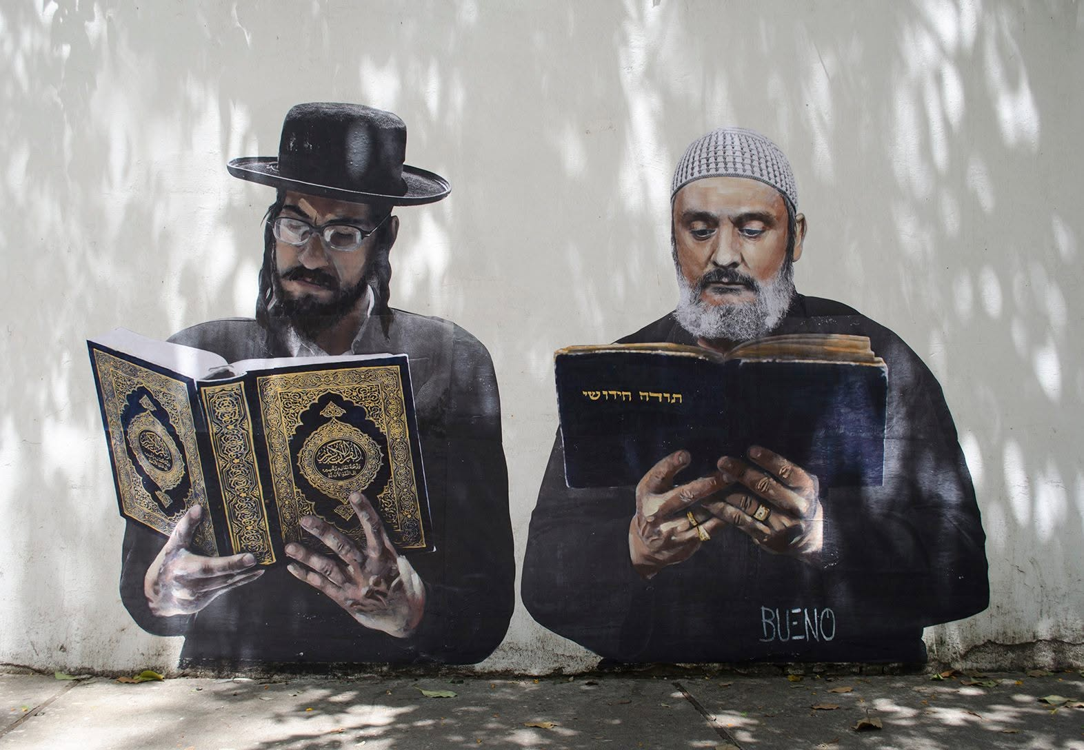 Mural showing a Jewish man and a Muslim man reading side by side